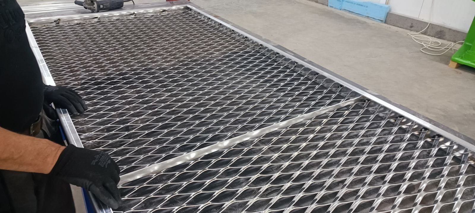 Metal mesh panel being assembled in a workshop