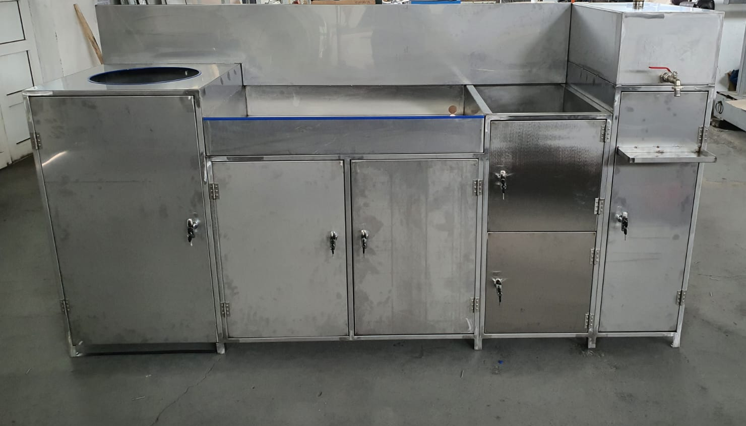 Functional assembly with doors, work surface, circular opening and tap; manufacturing-network example