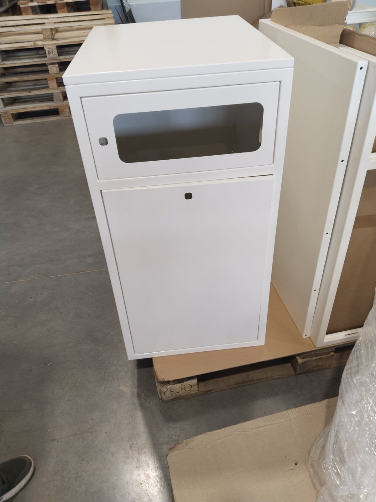 Upright enclosure with an upper viewing opening and lower access door.